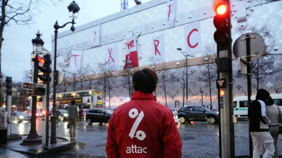 Des militants d'Attac déploient une banderole géante sur le futur hôtel Vuitton à Paris